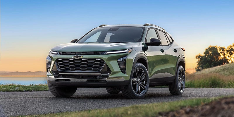 Green Chevrolet Trax SUV, front view, parked at sunset