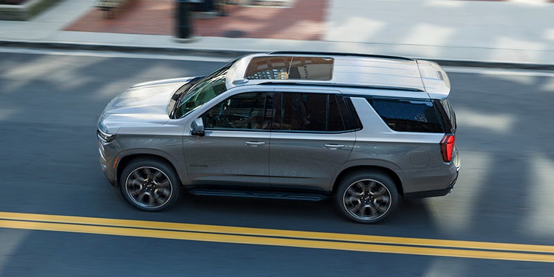 Gray Chevrolet Tahoe SUV driving on a city street
